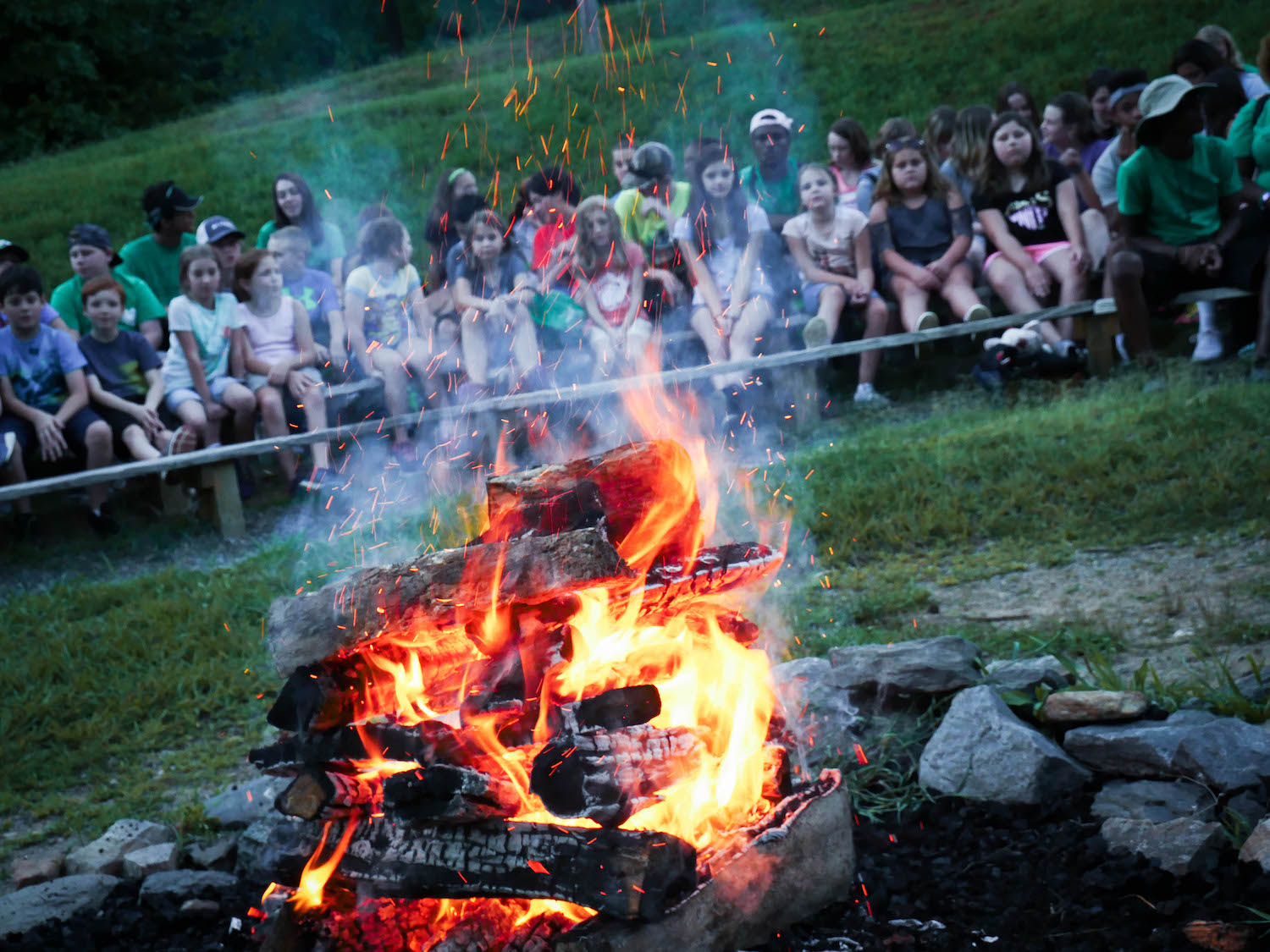 4-H campers sit around a firepit