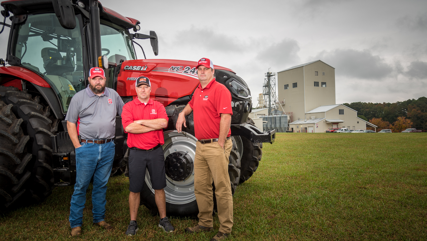 Chad Carter, Philip Newton and Bill Whaley stand in front of a tractor