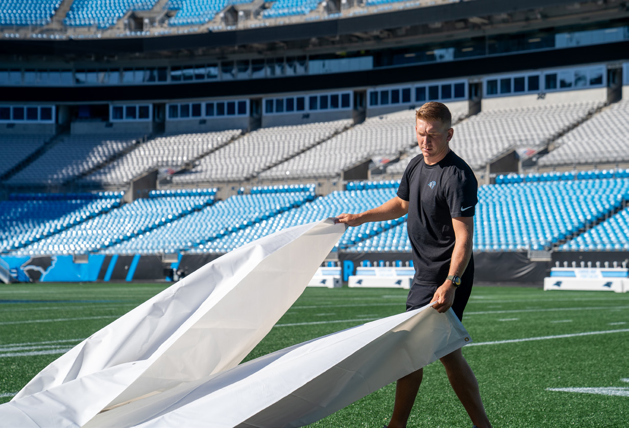 Man positioning a stencil on the football field