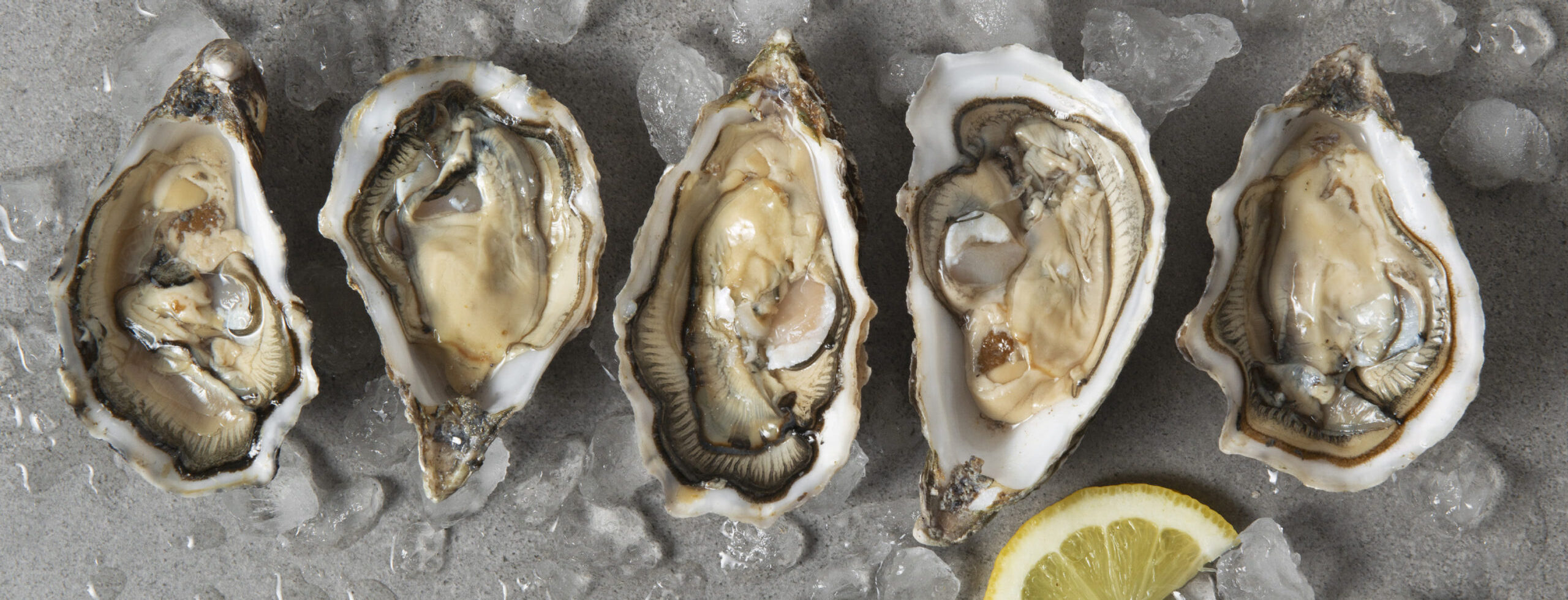 five oysters on ice with a lemon
