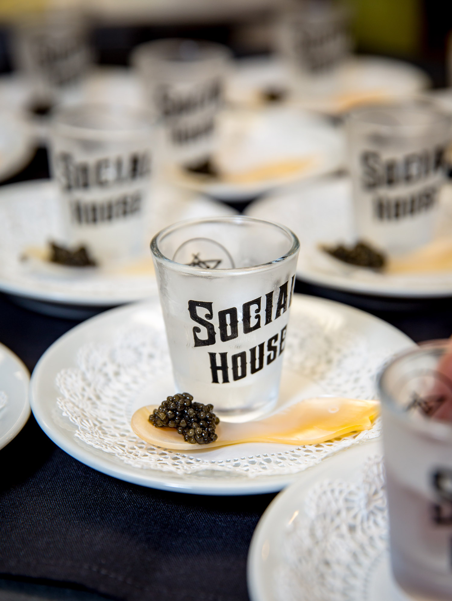 A social house shot glass sits on a plate.