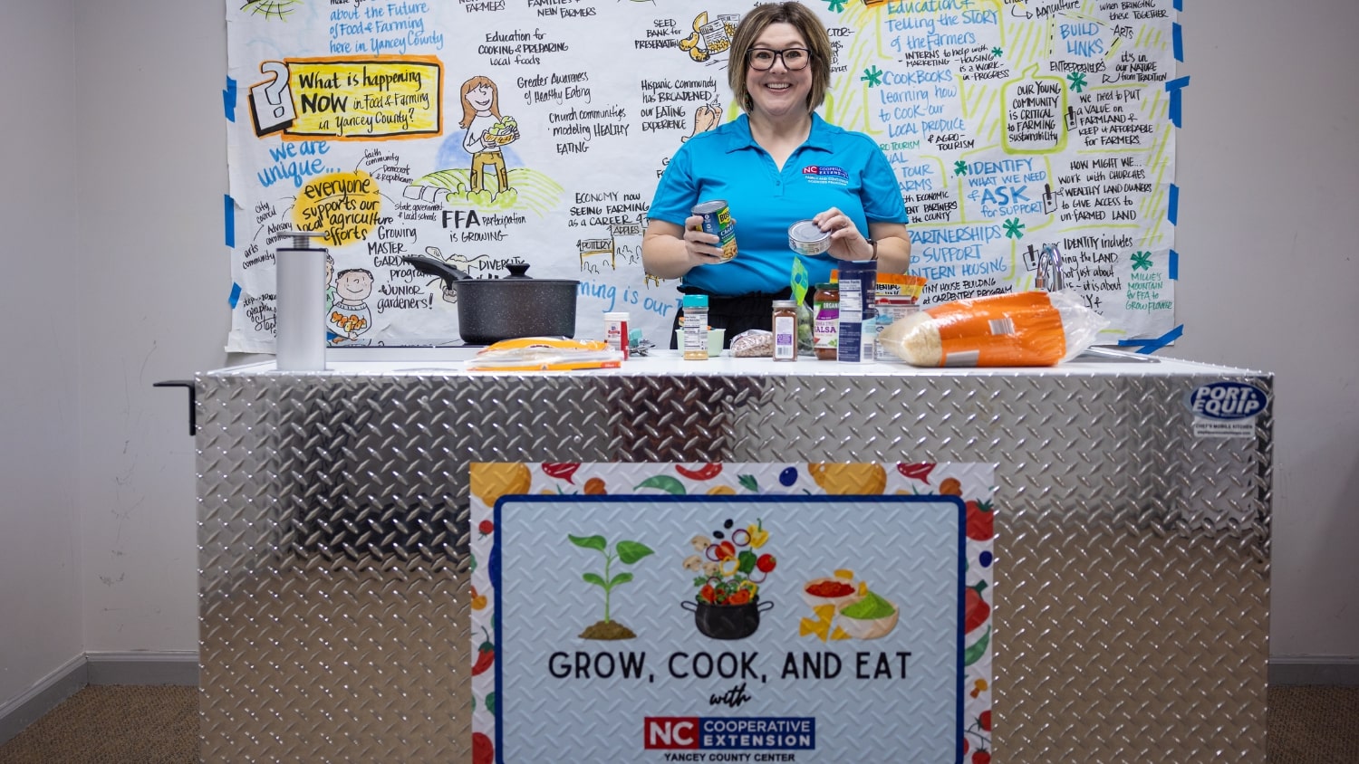 woman standing behind a table with cooking supplies